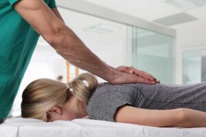 Two people talking about back pain while sitting in a living room with supportive furniture.